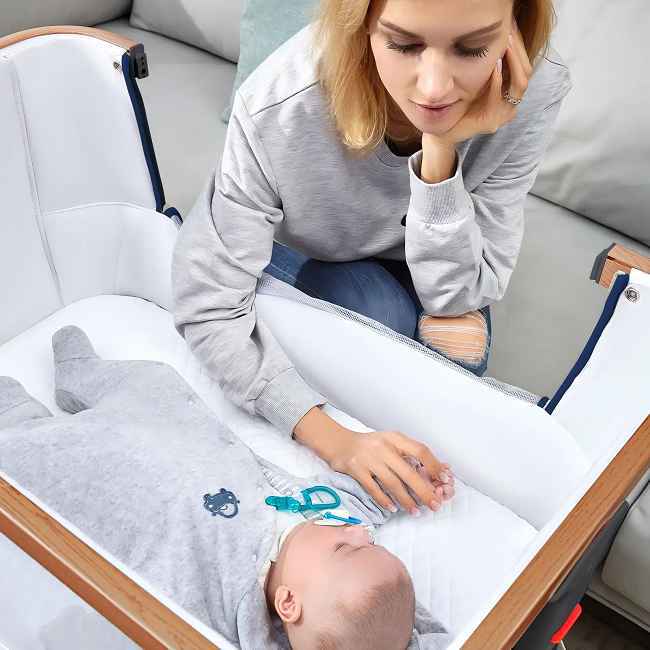 Designed for Shared Care:
Adjusts to 9 precise heights, matching any adult bed or sofa height.
Allows both mom and dad easy access day or night for feeding, comforting, or simply checking in without straining.

Built for Safety & Years of Use:
Features market-leading structural stability, proven to help babies settle and sleep more soundly.
Constructed with rigorously tested, durable materials.

Close Bonding & Convenience:
The front panel closest to parents lowers smoothly, letting you soothe or lift out your baby instantly without leaving your own bed. Builds security through proximity.

Hygienic Comfort, Long-Term Value:
Includes a soft, skin-friendly, fully washable mattress cover.                      Simplifies cleaning and ensures a fresh, healthy sleep surface for your growing child.

Adapts as Your Baby Grows:
Offers versatility with optional add-on functions: a gentle Swing mode or a compact Basket configuration for flexible sleeping/napping solutions throughout infancy.

Manufactured with strict quality control at our reputable Chinese factory, ensuring dependable performance and durability directly from the source.